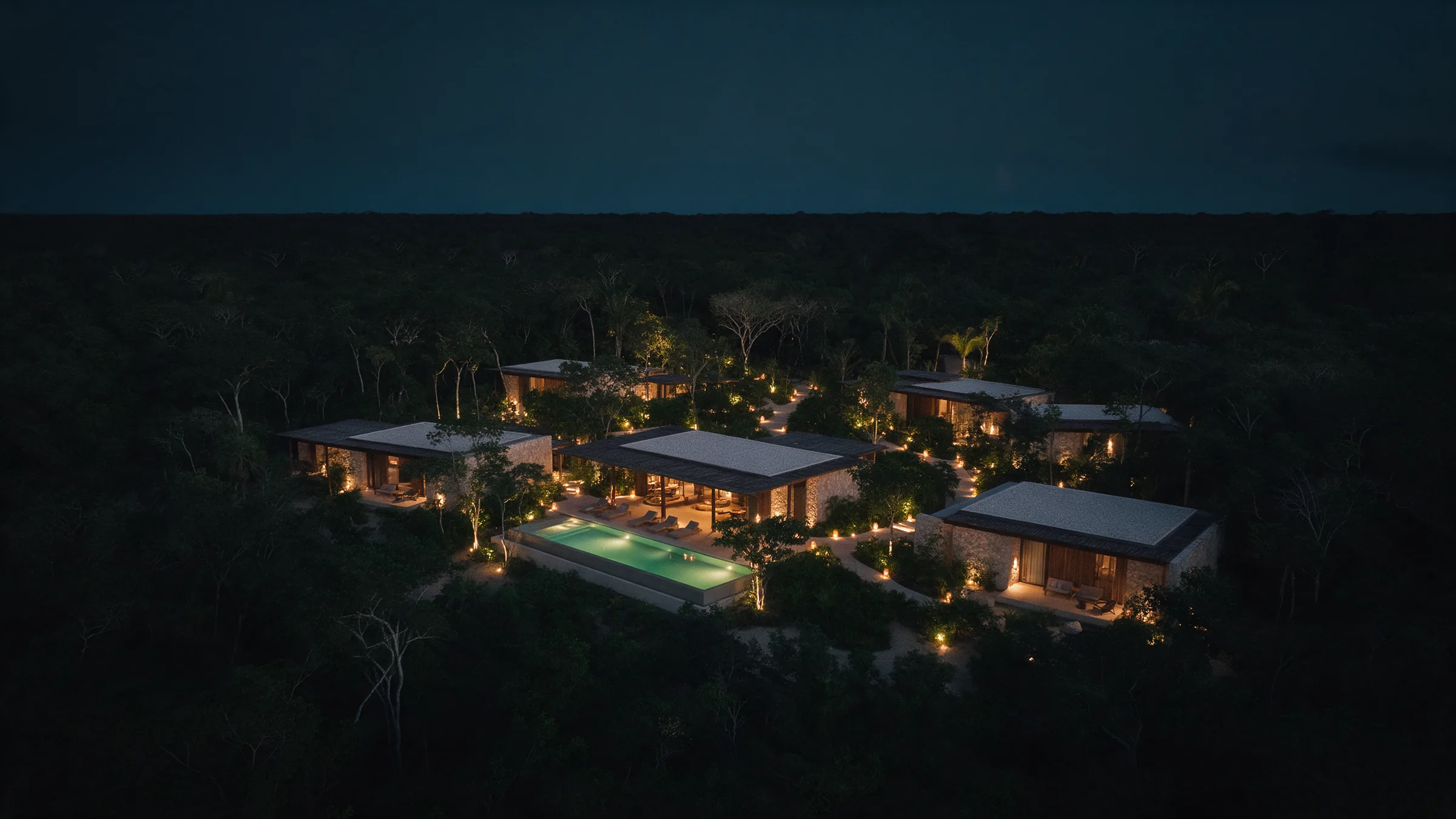 Resort contemporâneo iluminado na floresta, visto do alto à noite